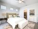 Stylish main bedroom features a plush bed, modern decor, carpet flooring, and a view into the ensuite bathroom at 3751 Lana Ave, Davenport, FL 33897