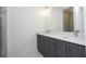 Modern bathroom featuring gray cabinets, double sinks, and a glass-enclosed shower at 41975 Aspen St, Eustis, FL 32736