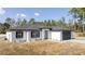 Beautiful one-story home with black shutters and a gray front door, surrounded by green trees at 41975 Aspen St, Eustis, FL 32736