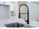 Close up of the stainless steel kitchen sink, light countertops and a modern matte black faucet at 41975 Aspen St, Eustis, FL 32736