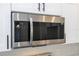 Close up of a modern stainless steel microwave with tile backsplash and white cabinets at 41975 Aspen St, Eustis, FL 32736