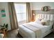 Bedroom featuring a padded headboard, neutral decor, and bright natural light from the window at 4289 Prologue Way, Kissimmee, FL 34746