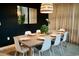 Dining area with a modern table, pendant lighting, and dark accent wall at 4289 Prologue Way, Kissimmee, FL 34746