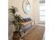 Inviting entryway with a rustic wooden bench, round mirror, and decorative plant at 4289 Prologue Way, Kissimmee, FL 34746