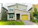 Modern two-story home with a stone facade and a bright yellow garage door at 4289 Prologue Way, Kissimmee, FL 34746