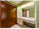 A bathroom featuring a single sink vanity and a dark-wood sliding closet door at 4355 Watermill Ave, Orlando, FL 32817