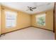 Bedroom featuring neutral carpet, two windows with blinds, and a ceiling fan at 4355 Watermill Ave, Orlando, FL 32817