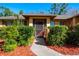 Home's front entrance with red mulch, walkway, mature landscaping, and a screen door at 4355 Watermill Ave, Orlando, FL 32817