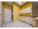 Kitchen featuring tile floors, natural light, and bright yellow walls at 4355 Watermill Ave, Orlando, FL 32817