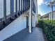 Close-up of the condo's outdoor entrance featuring a painted doorstep, the front door, and black wooden stairs at 4405 S Semoran Blvd # 7, Orlando, FL 32822