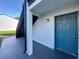 Unit #7, close-up of condo entrance with covered landing and painted blue door at 4405 S Semoran Blvd # 7, Orlando, FL 32822