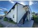 Two-story condo building featuring neutral-toned stucco, black trim, a staircase and well-maintained landscaping at 4405 S Semoran Blvd # 7, Orlando, FL 32822