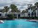 Beautiful community pool with palm trees and lush landscaping, perfect for relaxation and leisure at 4405 S Semoran Blvd # 7, Orlando, FL 32822