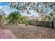 View of backyard with mature trees and wood privacy fence at 4898 Meadow Dr, St Cloud, FL 34772