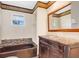 Bathroom with bronze tub and granite vanity with matching framed mirror at 4898 Meadow Dr, St Cloud, FL 34772