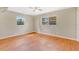 Bright bedroom featuring hardwood floors, ceiling fan, and two windows for natural light at 4898 Meadow Dr, St Cloud, FL 34772