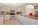 Functional kitchen with white cabinets, tile countertops, and stainless steel appliances at 4898 Meadow Dr, St Cloud, FL 34772