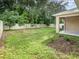 Spacious backyard features a white fence, lush trees, and a covered patio at 515 Darshire Ave, Eustis, FL 32736