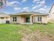 View of the exterior backyard with a covered patio and lush green lawn at 515 Darshire Ave, Eustis, FL 32736