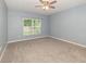 A well lit bedroom with carpet, ceiling fan and a double hung window at 515 Darshire Ave, Eustis, FL 32736