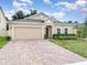 Well-maintained single-story home featuring a brick driveway and tidy landscaping at 515 Darshire Ave, Eustis, FL 32736