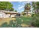 Expansive backyard and lush landscaping, with a screened in lanai and mature trees at 59 Aberdeen Cir, Leesburg, FL 34788