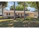 Charming single-story home featuring mature landscaping, vinyl siding, and an inviting front entrance with brick facade at 59 Aberdeen Cir, Leesburg, FL 34788