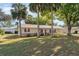 Inviting single-story home with lush landscaping, a screened front porch, and beautiful trees at 59 Aberdeen Cir, Leesburg, FL 34788