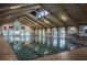 Indoor swimming pool featuring skylights and wood beam architecture at 59 Aberdeen Cir, Leesburg, FL 34788