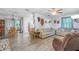 Bright living room flows into the dining area, offering ample seating and stylish flooring at 59 Aberdeen Cir, Leesburg, FL 34788