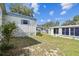 View of the white siding of this mobile home with partial lawn in a peaceful backyard setting at 7 Great Oak Dr, Fruitland Park, FL 34731