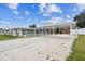 Community carport offering shade and parking with view of shuffleboard courts and golf cart parking at 7 Great Oak Dr, Fruitland Park, FL 34731