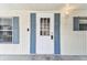 Inviting front door with blue shutters and a modern digital lock at 7 Great Oak Dr, Fruitland Park, FL 34731