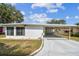 Single story home with covered parking and a well-maintained lawn under a sunny sky at 7 Great Oak Dr, Fruitland Park, FL 34731