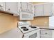 A close-up of the white electric range and the microwave above with a wood trimmed countertop at 7 Great Oak Dr, Fruitland Park, FL 34731