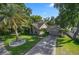 Aerial view of a well-manicured lawn, a palm tree, and a long driveway leading to a well-maintained home at 703 E Lakeshore Dr, Ocoee, FL 34761