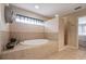 Bathtub and shower with tile surround and glass block window at 703 E Lakeshore Dr, Ocoee, FL 34761