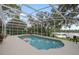 Gorgeous pool with a screened enclosure, surrounded by lush greenery, offering a private escape at 703 E Lakeshore Dr, Ocoee, FL 34761