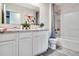 Bathroom featuring white cabinetry, granite counters, bathtub and shower with neutral colored shower curtain at 7104 Painted Bunting Way, St Cloud, FL 34773