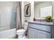 Bathroom featuring white toilet and vanity with gray cabinets and granite countertops and bathtub/shower at 7104 Painted Bunting Way, St Cloud, FL 34773