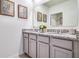 Bathroom featuring double vanity with gray cabinets and granite countertops, decorated with botanical artwork at 7104 Painted Bunting Way, St Cloud, FL 34773