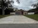 Charming single-story home featuring a spacious driveway and a well-maintained lawn with decorative white fencing at 7132 Laurel Hill Dr, Orlando, FL 32818