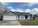 Charming single-story home with a two-car garage, arched windows, and a well-maintained lawn at 7277 Pebble Pass Loop Loop, Lakeland, FL 33810