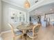 Charming dining area with a round wooden table, upholstered chairs, and a view into the modern kitchen at 7515 John Hancock Dr, Winter Garden, FL 34787