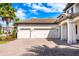 Home's spacious three-car garage with a brick driveway and mature landscaping at 7515 John Hancock Dr, Winter Garden, FL 34787