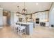 The bright white kitchen features a large island with seating and pendant lighting at 7515 John Hancock Dr, Winter Garden, FL 34787