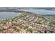 Scenic aerial view of a community with lakes, green spaces, and terracotta-roofed houses at 8218 Borgia Ct, Orlando, FL 32836