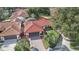 Aerial view of house with a red tile roof, well-manicured lawn, and brick driveway in a residential neighborhood at 8218 Borgia Ct, Orlando, FL 32836