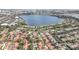 Expansive aerial view showcasing a lakeside community with neat homes, gardens, and a blue lake at 8218 Borgia Ct, Orlando, FL 32836