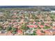 Wide aerial view of a neighborhood with lush trees and terracotta-roofed homes near town center at 8218 Borgia Ct, Orlando, FL 32836